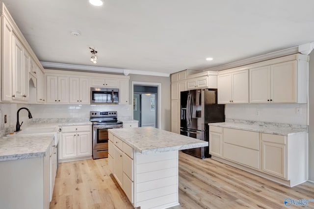 kitchen with appliances with stainless steel finishes, crown molding, decorative backsplash, a kitchen island, and light wood-type flooring