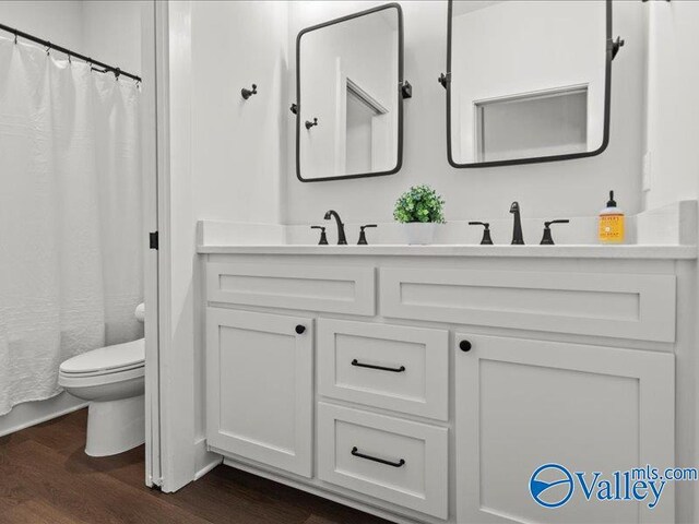 23819 Justin Brent Cir, Elkmont, AL 35620 - full bathroom featuring toilet, wood finished floors, double vanity, and a shower with curtain