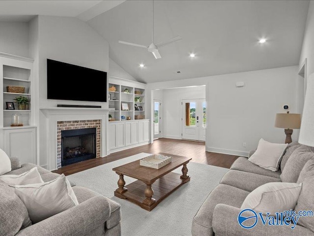 23819 Justin Brent Cir, Elkmont, AL 35620 - living room featuring lofted ceiling, wood finished floors, built in features, a ceiling fan, and a brick fireplace