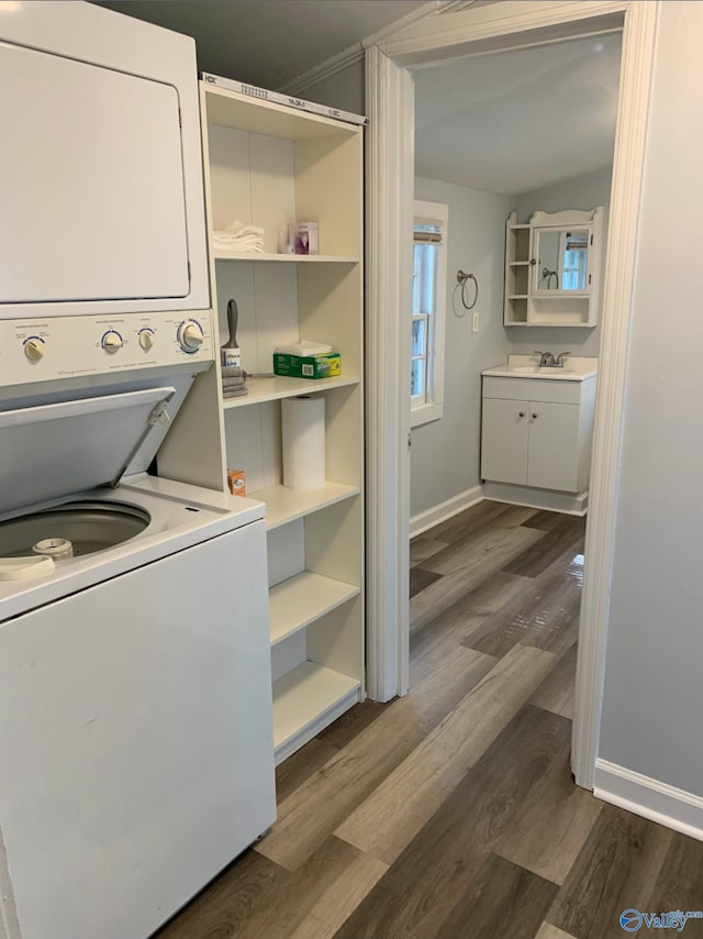 505 Mccullough Ave NE, Huntsville, AL 35801 - clothes washing area featuring stacked washer / dryer, laundry area, a sink, baseboards, and dark wood-style flooring