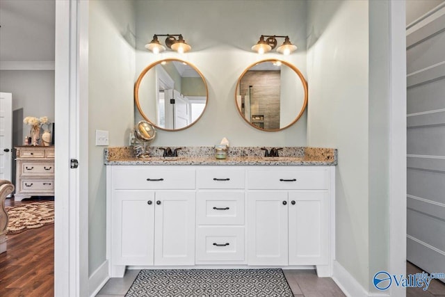 bathroom featuring tile patterned floors, ornamental molding, and vanity