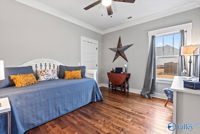 bedroom with ceiling fan, ornamental molding, and dark hardwood / wood-style flooring