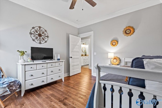 bedroom with crown molding, dark hardwood / wood-style floors, and ceiling fan