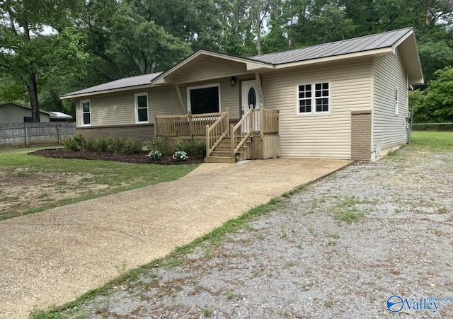 230 Hampton Rd, Hartselle, AL 35640 - view of front of house featuring fence, metal roof, view of scattered trees, and a deck