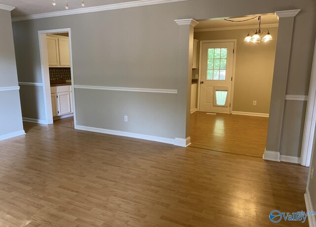 230 Hampton Rd, Hartselle, AL 35640 - unfurnished room with light wood finished floors, a chandelier, ornamental molding, and baseboards