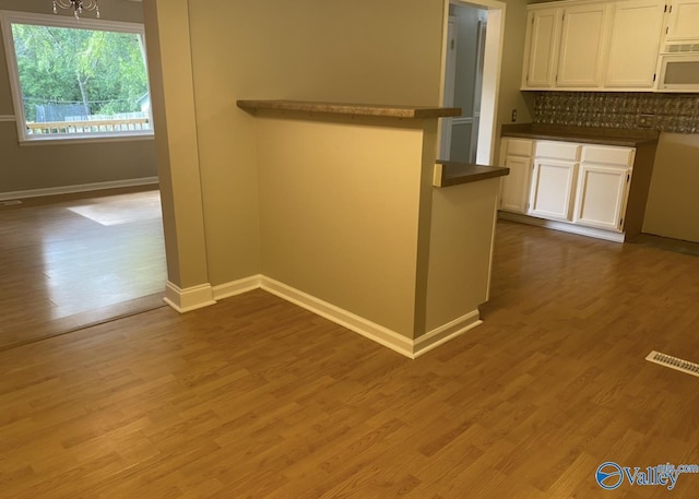230 Hampton Rd, Hartselle, AL 35640 - kitchen with white microwave, dark countertops, baseboards, and white cabinetry