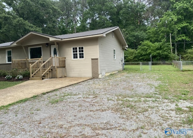230 Hampton Rd, Hartselle, AL 35640 - view of front facade featuring fence, view of scattered trees, and metal roof