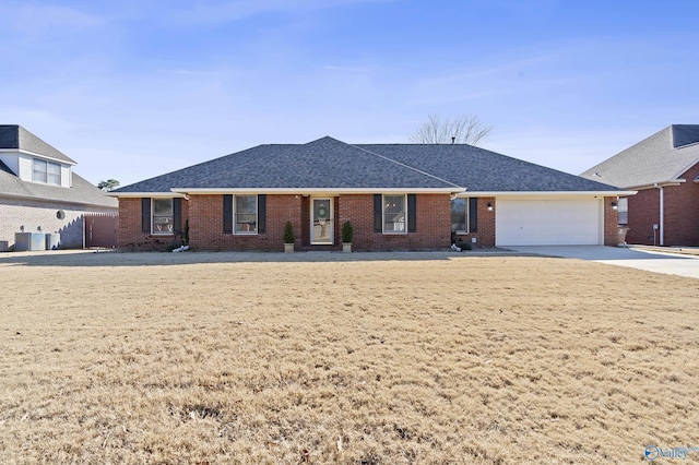 ranch-style home with a garage and central air condition unit