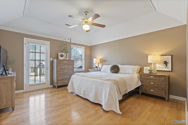 bedroom featuring access to exterior, ceiling fan, light hardwood / wood-style floors, and a raised ceiling