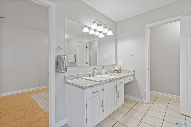 bathroom with tile patterned flooring, a textured ceiling, and vanity