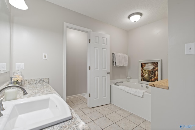bathroom featuring tile patterned flooring, vanity, a textured ceiling, and a washtub