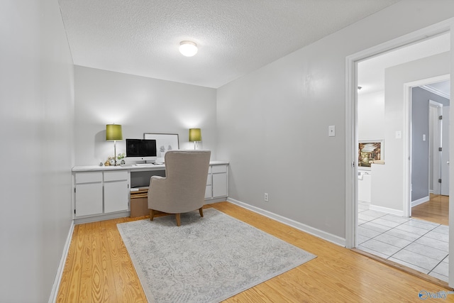 office with a textured ceiling and light hardwood / wood-style floors