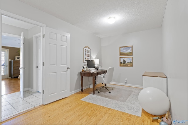 office space with a textured ceiling and light hardwood / wood-style floors
