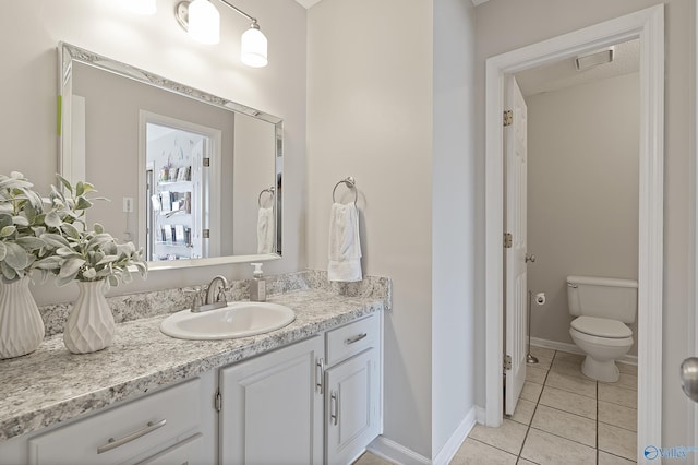 bathroom featuring tile patterned floors, vanity, and toilet