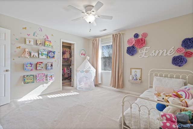 carpeted bedroom featuring a closet, a spacious closet, and ceiling fan