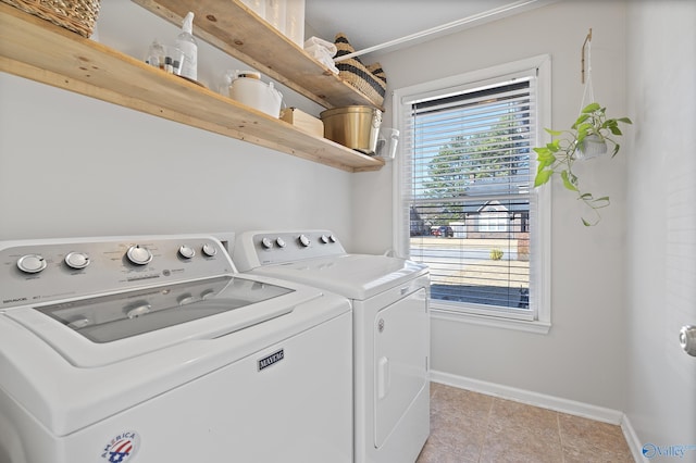 laundry room featuring a wealth of natural light, light tile patterned floors, and washer and clothes dryer