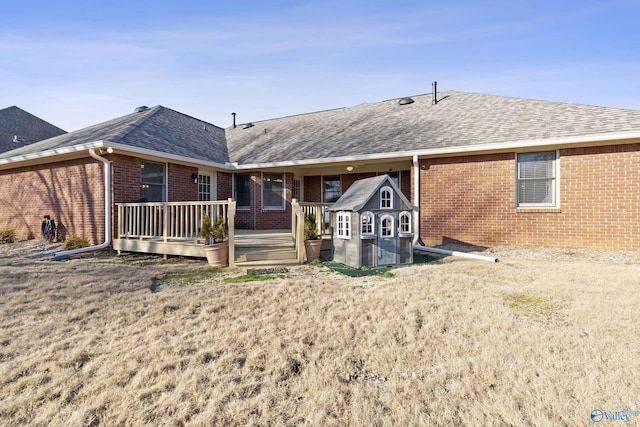 rear view of property featuring a wooden deck