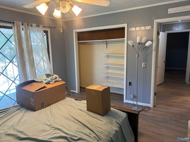 bedroom with baseboards, ornamental molding, and wood finished floors