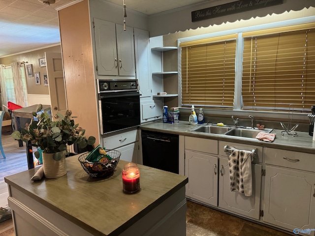 kitchen with white cabinetry, ornamental molding, and black appliances