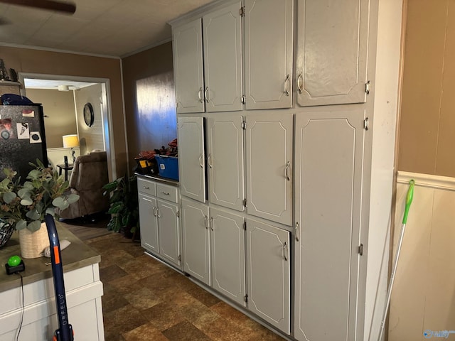 kitchen with electric panel, white cabinetry, crown molding, and freestanding refrigerator