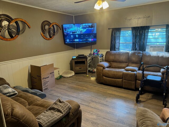 living room with hardwood / wood-style floors, cooling unit, a textured ceiling, ceiling fan, and crown molding