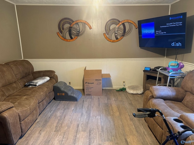 living area with wood finished floors and wainscoting