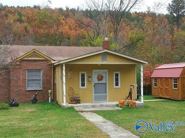 view of front of home with a front yard and a storage unit