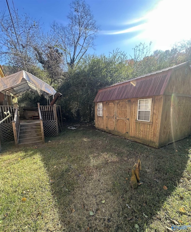 view of yard featuring a wooden deck and a storage unit