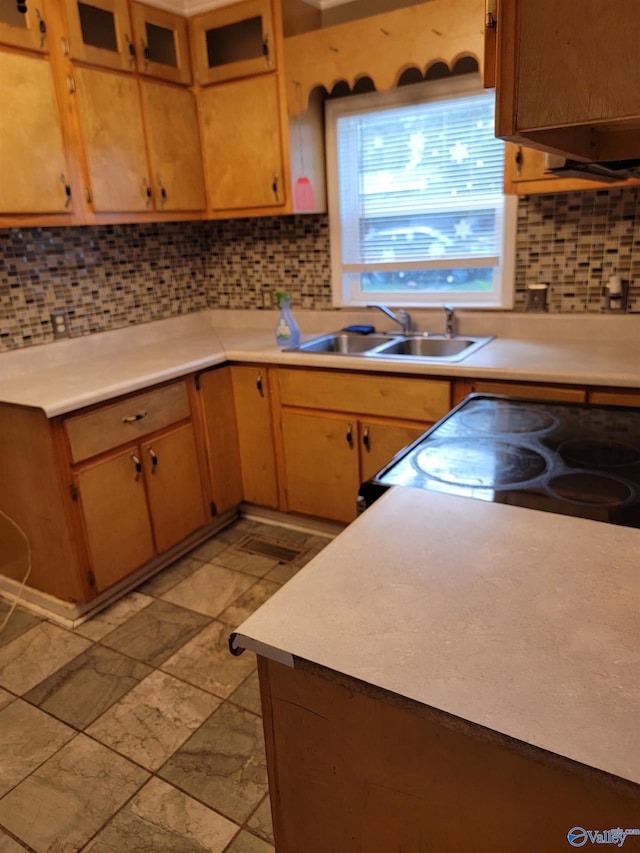 kitchen featuring decorative backsplash, stove, and sink