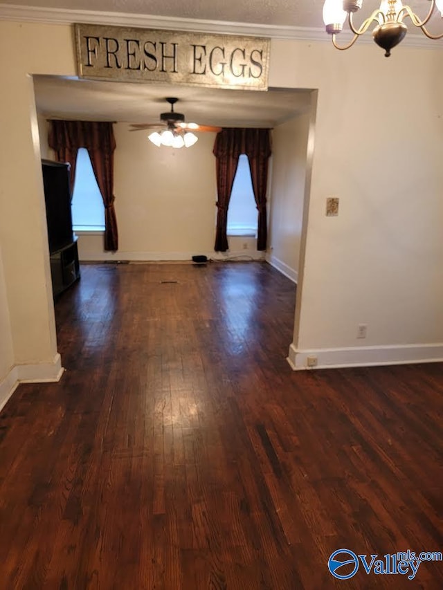 interior space with dark hardwood / wood-style flooring, ceiling fan with notable chandelier, and ornamental molding