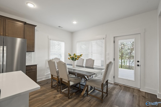 dining room with dark hardwood / wood-style flooring and a healthy amount of sunlight