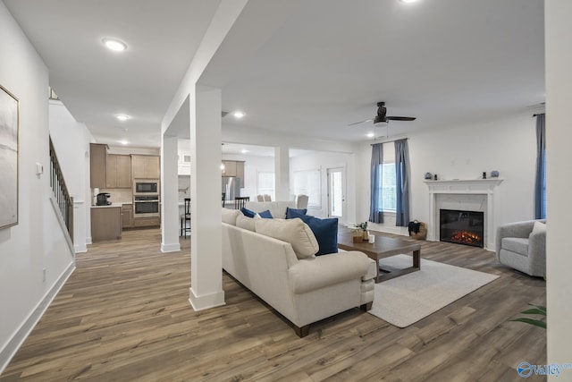 living room featuring ceiling fan and dark wood-type flooring