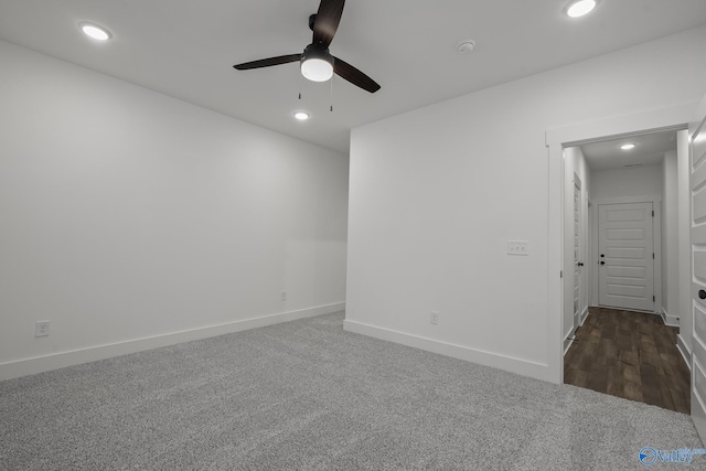 spare room with ceiling fan and dark carpet