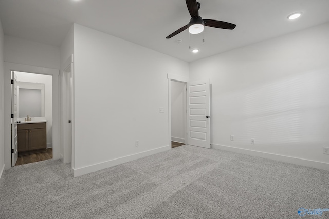 unfurnished bedroom with ceiling fan, sink, carpet, and ensuite bathroom