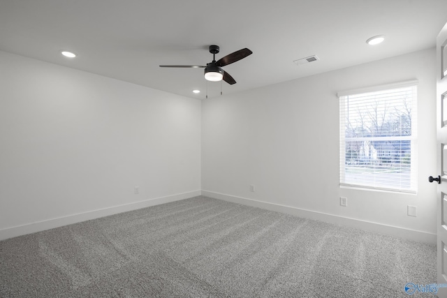 unfurnished room with ceiling fan and carpet