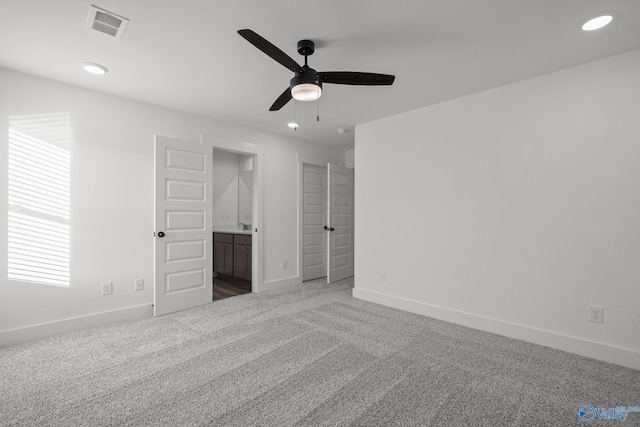 unfurnished bedroom featuring carpet flooring, ceiling fan, and ensuite bath