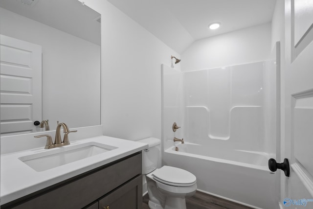 full bathroom featuring washtub / shower combination, wood-type flooring, lofted ceiling, toilet, and vanity