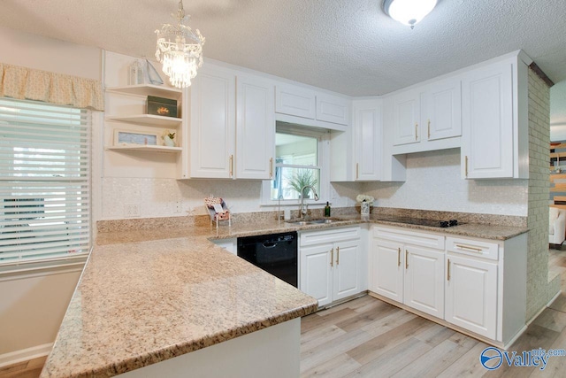 kitchen featuring sink, decorative light fixtures, white cabinetry, and light hardwood / wood-style floors