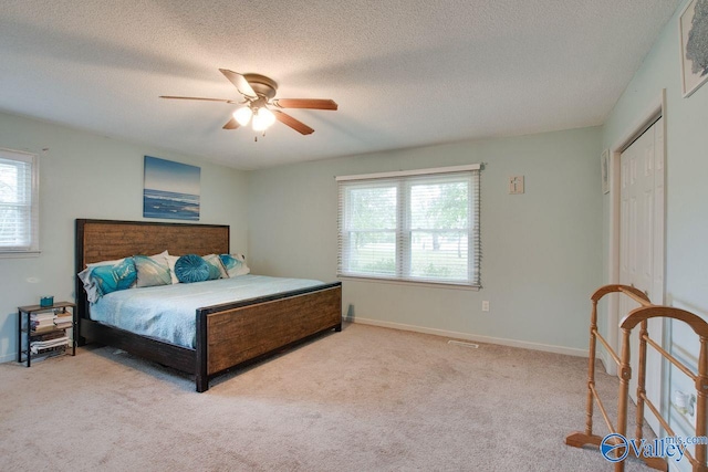 bedroom with multiple windows, light colored carpet, and ceiling fan