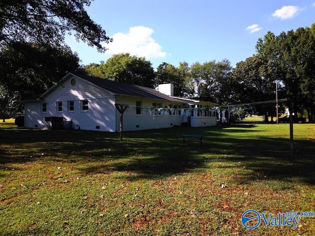 view of side of home with a yard