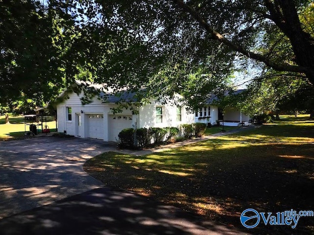 view of front of property featuring a front lawn and a garage