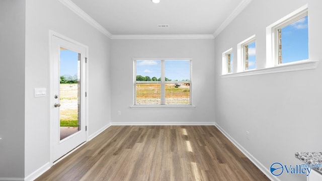 empty room featuring crown molding and wood-type flooring