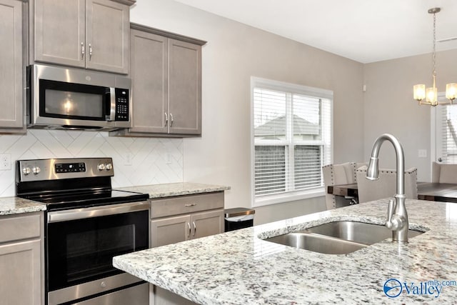 114 Burdine St, New Market, AL 35761 - kitchen featuring stainless steel appliances, a sink, a chandelier, backsplash, and pendant lighting