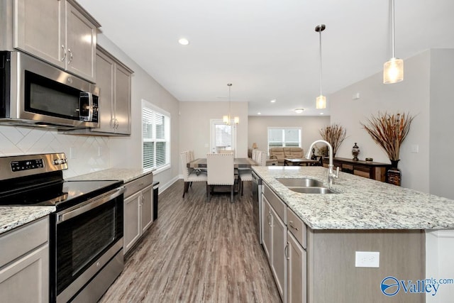 114 Burdine St, New Market, AL 35761 - kitchen featuring appliances with stainless steel finishes, a sink, wood finished floors, tasteful backsplash, and plenty of natural light