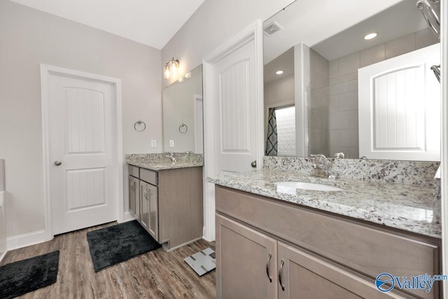 114 Burdine St, New Market, AL 35761 - full bathroom with wood finished floors, two vanities, baseboards, and a tile shower