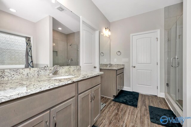 114 Burdine St, New Market, AL 35761 - bathroom with wood finished floors, a shower stall, two vanities, and baseboards
