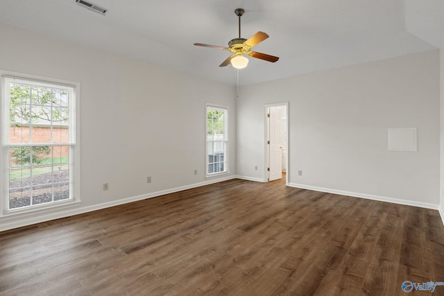 empty room with ceiling fan and dark hardwood / wood-style flooring