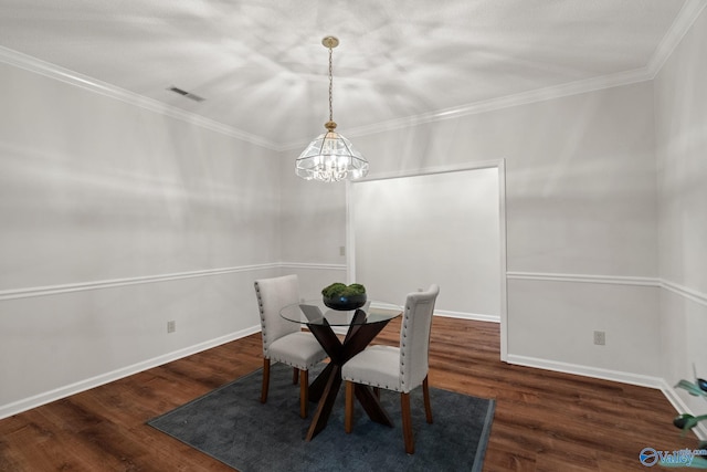 dining area featuring dark hardwood / wood-style flooring, ornamental molding, and an inviting chandelier