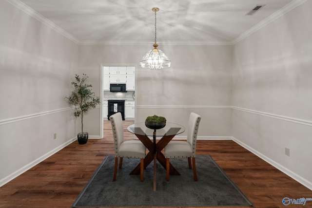 dining area with dark wood-type flooring, a notable chandelier, and ornamental molding