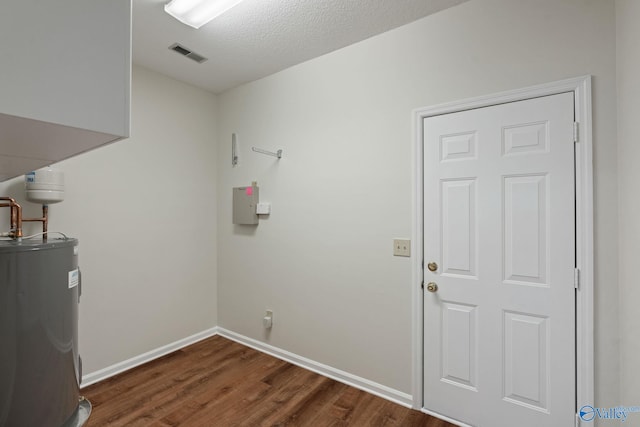 washroom with electric water heater, dark wood-type flooring, and a textured ceiling